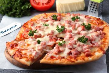 Pizza dengan sosis, tomat, dan keju